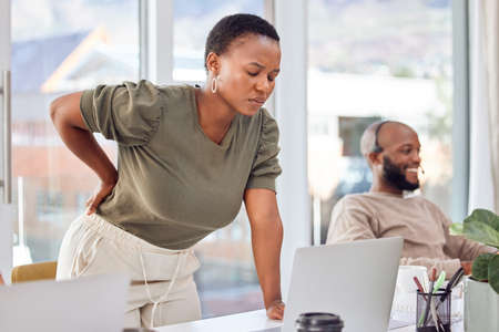 Could it be my chair or something else.... Shot of a businesswoman experiencing back pain while...