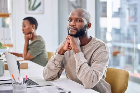 If you want to be successful, hard work is a necessity. Portrait of a confident businessman sitting at his desk.の写真素材