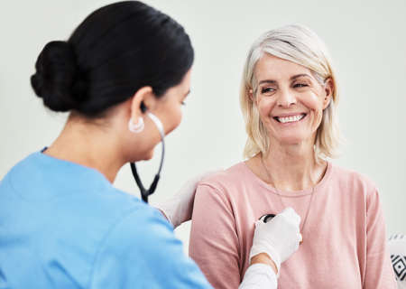 Living life with a positive attitude and a healthy heart. Shot of a female doctor examining a patient with a stethoscope.の写真素材