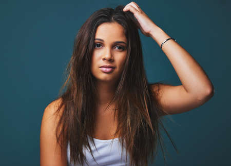 Life lesson opinions are just benign gestures. Portrait shot of a beautiful young woman posing against a blue background.の写真素材
