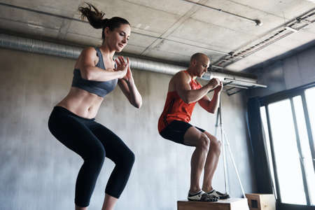 Reach your beast mode. Shot of a man and woman training together at the gym.の写真素材