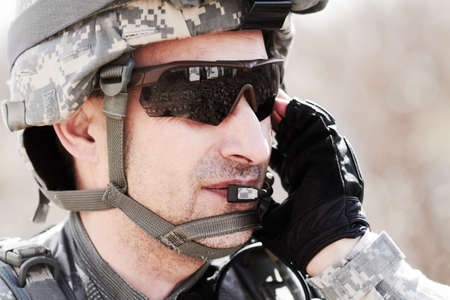 Keeping communication on command. Closeup profile of a soldier communicating on his headset.の写真素材