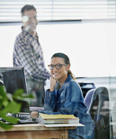 I love my work. Cropped portrait of two young designers working on a pc.