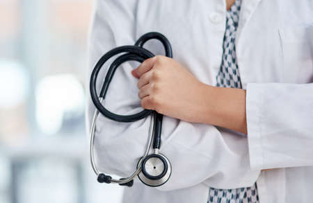 The doctor will see you now. Cropped shot of an unrecognisable doctor holding a stethoscope and crossing her arms.の写真素材