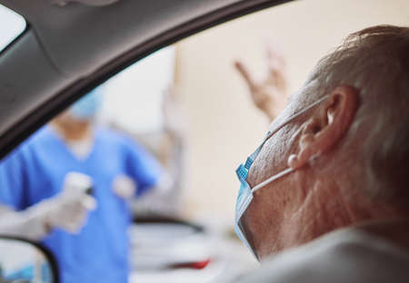 Thank you for the swift service. Shot of a senior man waving at a healthcare worker while in his car...