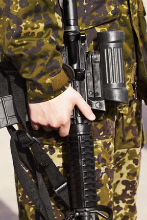 His trusty weapon. Cropped image of a soldiers hand holding a rifle.