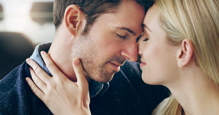 Cherishing the moment. Cropped shot of an affectionate young couple sharing a loving moment in their home.の写真素材