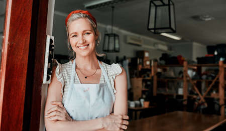 Please, come in. Cropped portrait of an attractive mature woman standing with her arms folded in her pottery workshop.の写真素材