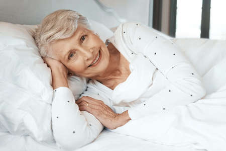 Shot of a senior woman relaxing in bed in a nursing homeの写真素材