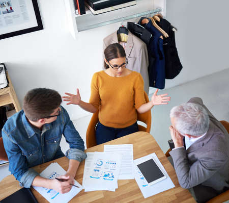 Shot of a young businesswoman explaining something to her colleagues in a meeting