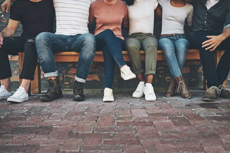 The bond on the bench. Shot of a group of unrecognizable people sitting outside.の写真素材