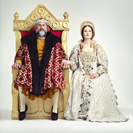 They rule sternly but fairly. Studio shot of a king and queen sitting on thrones.の写真素材
