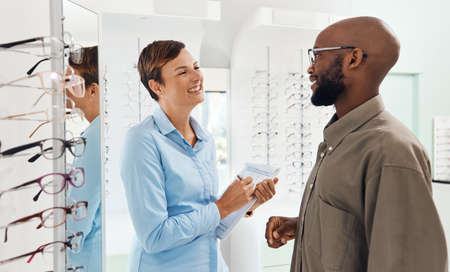 If youre happy, Im happy. Shot of a an optometrist helping a young man choose a new pair of glasses.