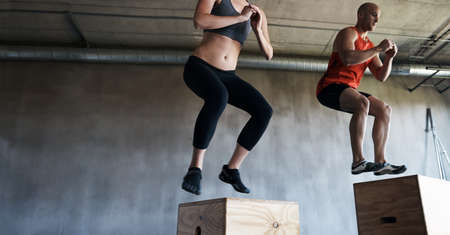 Reach your beast mode. Shot of a man and woman training together at the gym.の写真素材