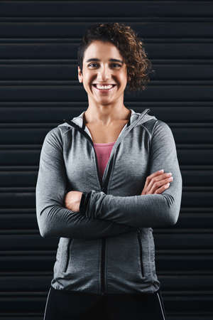 Being healthy makes me happy. Cropped portrait of an attractive young woman standing against a black...