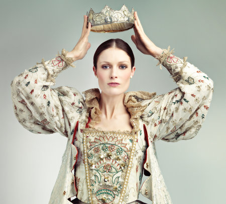 Long live the Queen. Shot of queen holding a crown over her head.の写真素材
