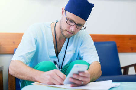 When hes not with patients, hes doing paperworkの写真素材