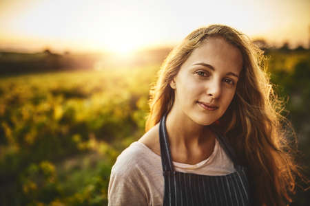 The farm life is for me. Portrait of a young woman working on a farm.の写真素材