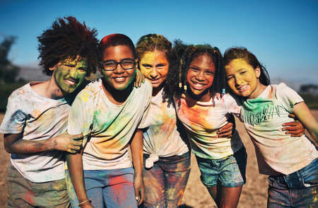 Friends fill your life with color. Shot of a group of teenagers having fun with colourful powder at summer camp.の写真素材