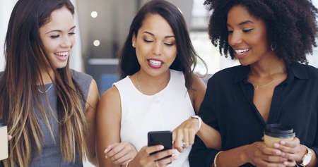 Check this out. Cropped shot of three young beautiful businesswomen walking through a modern office.の写真素材