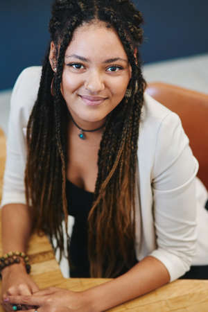 Things are looking up. Cropped portrait of an attractive young woman sitting in her home office.の写真素材