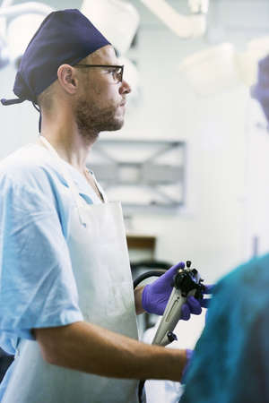 The focus is on saving lives. Shot of a young surgeon performing surgery on a patient in an operating room.の写真素材