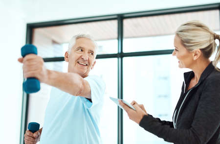 Youre are doing better each day. Shot of a physiotherapists helping her senior patient with his...
