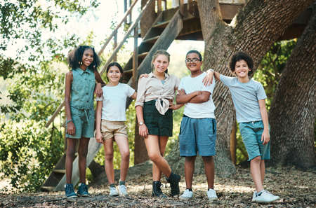 A home away from home. Shot of a group of teenagers standing next to a tree at summer camp.