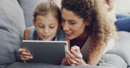 Sharing her daughters internet interests. 4k video footage of a mother and her little daughter lying...