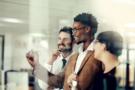 Running through the plan with the team. Cropped shot of a group of businesspeople brainstorming with...