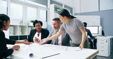 Turning dream building plans into reality. 4k video footage of a group of businesspeople working on...