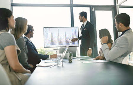Presenting ideas to the team. Shot of corporate businesspeople meeting in the boardroom.の写真素材