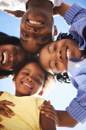 Putting their heads together. Low view portrait of a happy african-american family spending the day...