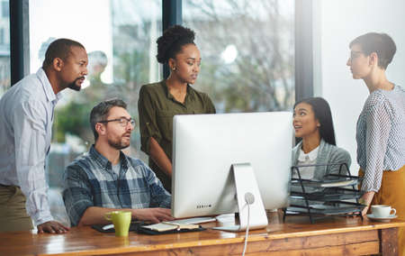 Working together to get the task done. Shot of businesspeople working together in the office.