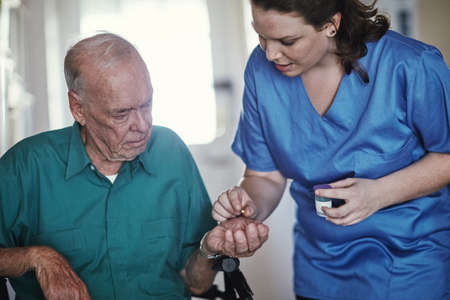 Dedicated to personal quality care. Shot of a female nurse assisting her senior patient.の写真素材