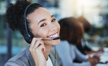 Well leave you smiling too by the end of the call. Portrait of a young woman working in a call...