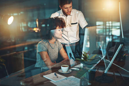 They work around the clock to satisfy their clients. Shot of colleagues working late at the office.