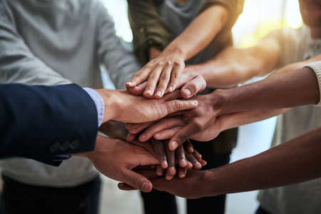 Theres nothing we cant do together. Cropped shot of a group of businesspeople joining their hands in...