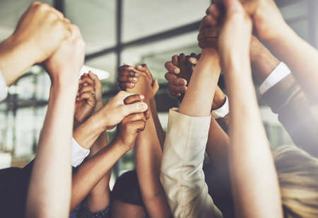 Together we can do anything. Cropped shot of a group of businesspeople holding hands.