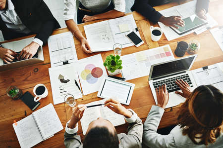 Unpacking it all. High angle shot of a group of businesspeople having a meeting in an office.