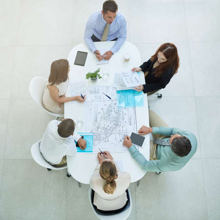 Theyre a dedicated group. High angle shot of a group of businesspeople meeting in the office.の写真素材