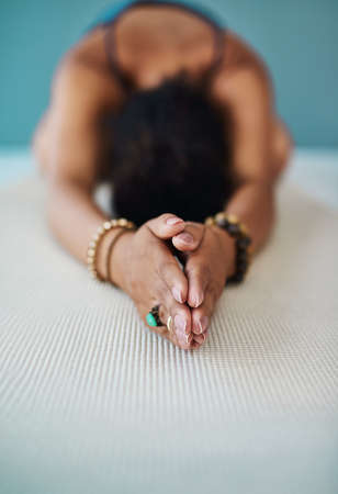 Working her way through the various positions. Shot of a young woman practising yoga.