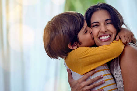 Shot of an adorable little boy affectionately kissing his mother at home