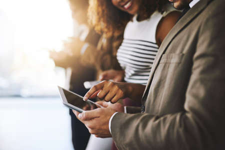 Keep all your information in one place. cropped shot of businesspeople using a digital tablet together.の写真素材