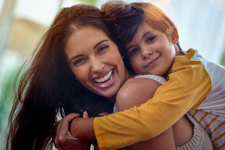 Mom, the best friend a boy could ever have. Shot of an adorable little boy affectionately hugging his mother at home.の写真素材