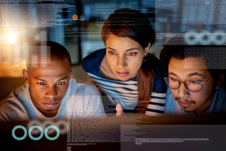 Trying to fix software issues together. Shot of computer programmers looking through data in the...