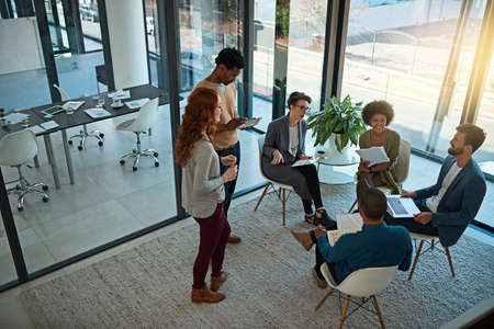 Strengthening partnerships through teamwork. Shot of a group of creatives having a meeting in a...