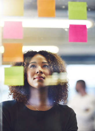 Thinking critically to create success. Shot of a young woman having a brainstorming session with...