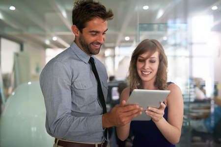 Making things happen with a digital brainstorming session. Shot of two colleagues using a digital...