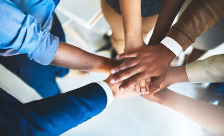 We are on a common mission. Cropped shot of a group of businesspeople piling their hands on top of...